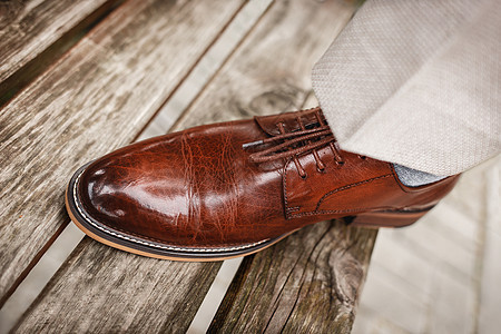 男人的棕色皮鞋 由真光滑的皮革制成配饰男性白色裤子男士套装靴子鞋类时尚衣服图片