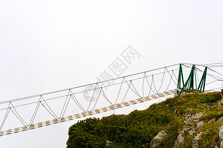雾天悬崖上空的绳桥风险深渊观光爬坡梯子山脉远足小路地标冒险图片