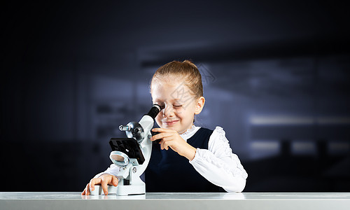 透过显微镜观察的小小科学家化学品知识教育女学生实验学生课堂学习研究员校服图片