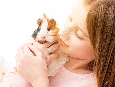 可爱的小女孩 在她的脸颊附近抱着小白鼠幸福哺乳动物金发女郎孩子友谊女孩朋友快乐宠物毛皮图片