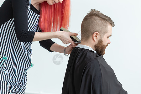 美发师 发型师和理发店的概念  女发型师剪胡须男客户男人女士成人沙龙发型修饰工作理发剪刀图片