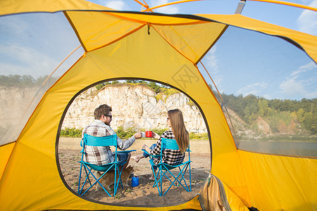 人 夏季旅游和自然概念  年轻夫妇在帐篷附近喝茶幸福青春期女性男性女士火焰枝条田园微笑冒险夫妻高清图片素材