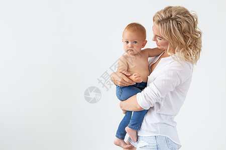 家庭 母亲身份和家庭观念 — 年轻母亲抱着她的孩子 背景是白色 有复制空间图片