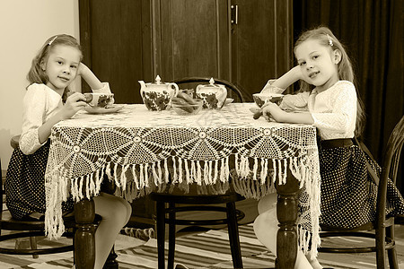 双胞胎在古老的桌子上喝茶微笑婴儿食物孩子童年派对孩子们青年女性杯子图片