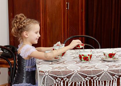 可爱的小女孩在旧桌边喝茶食物女性坡度孩子们青年婴儿杯子派对幸福孩子图片