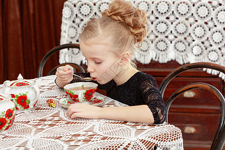美丽的小女孩在餐桌上喝茶 笑声婴儿派对孩子青年女性白色裙子杯子幸福食物图片