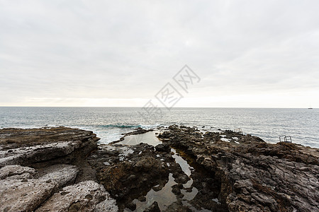 清晨平静的海洋 海边有石块海岸线旅游支撑海岸戏剧性蓝色海景场景旅行天空图片