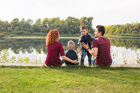 童年和自然概念     家庭 小儿子坐在绿草上头发女性卷曲男生儿子儿子们天空乐趣妈妈季节图片