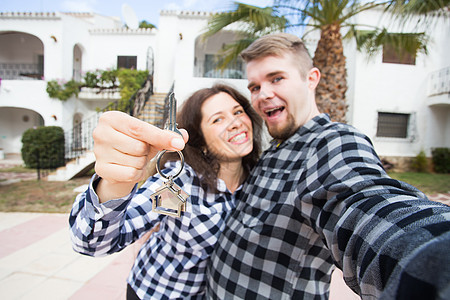 房地产 - 快乐的一对夫妇 展示了他们新房子的钥匙图片