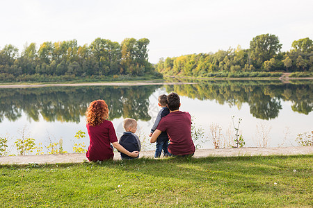 童年和自然概念     家庭 小儿子坐在绿草上父亲季节父母成人孩子们池塘头发男人女性太阳图片