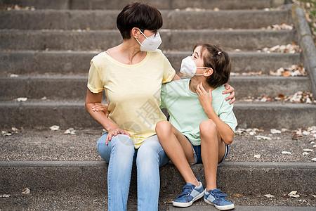 服装样机中年母亲和女儿穿着面具坐在街上 头戴面罩童年拥抱小样流感预防疾病孩子快乐肺炎单身背景