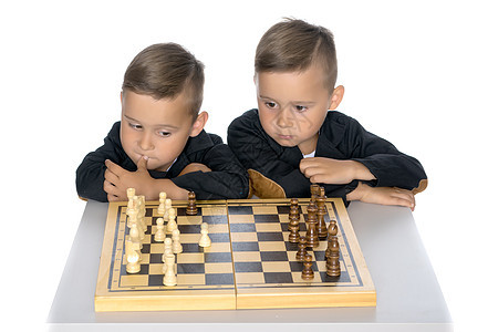两个小男孩下象棋竞赛棋盘童年青年女孩沉思兄弟幸福男人战略图片