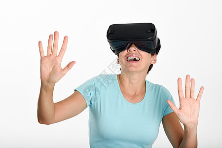 女人看着VR眼镜 用他的双手摆弄娱乐创新工作室闲暇红色模拟风镜耳机白色眼镜图片