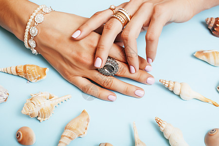 美丽的女性手和粉红修指甲 盘子上贴有珍珠和海壳 奢华珠宝概念宝石钻石首饰牡蛎美甲蓝色配件手指项链魅力图片
