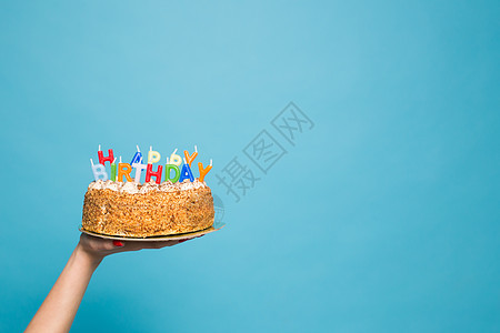 手握生日蛋糕 蜡烛和在蓝背景上登记生日 复制空间 Copy Space情绪艺术问候语工作室派对纪念日庆典创造力周年风格图片