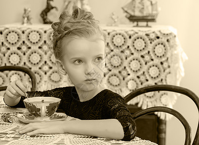 美丽的小女孩在餐桌上喝茶 笑声女性幸福童年青年微笑派对裙子婴儿杯子孩子图片