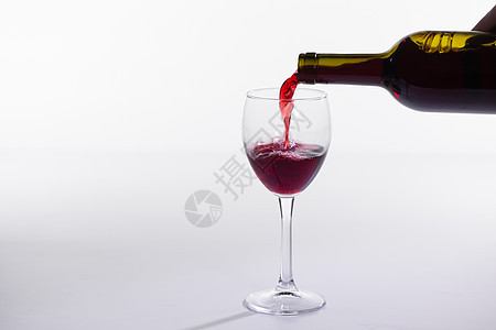 红酒瓶倒白底的玻璃派对饮料庆典酒杯瓶子飞溅美食纪念日酒吧运动图片