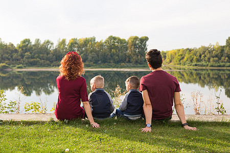 童年和自然概念     家庭 小儿子坐在绿草上乐趣男人女性男性儿子们卷曲天空儿子头发成人图片