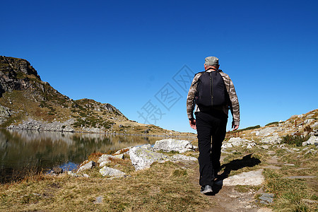 一个背着背包的男人去山上享受旅行假期远足游客活动男性旅游山脉运动图片