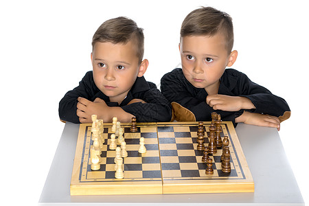 两个小男孩下象棋乐趣闲暇女孩活动青年房间爱好幸福孩子思考背景图片