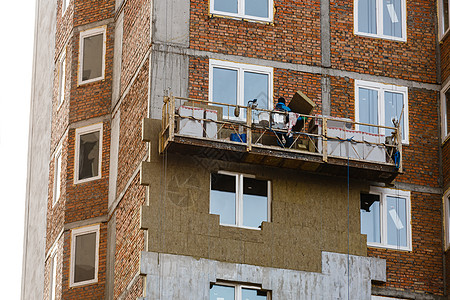 建筑工地上房屋墙壁的热绝缘绝缘材料工人能量能源矿棉安装建筑学建造泡沫手术图片