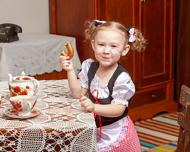 小女孩吃百吉饼面粉烹饪厨师小吃面包厨房营养面包师帽子烘烤图片