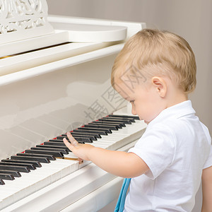 弹钢琴的小男孩幸福钢琴家教育键盘乐器活动学校学习男生合成器图片