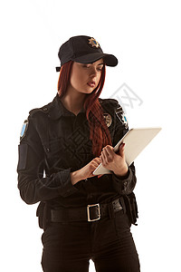 Redhead女警官正在为白色背景的隔离照相机摆姿势图片