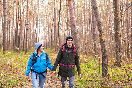 旅行 旅游 远足和人的概念  背着背包在秋天的森林里散步蓝色远足者三分球男人幸福成人紫色女士夹克游客图片