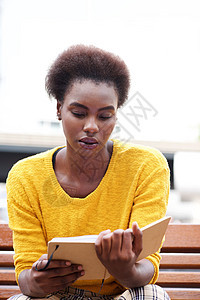非裔美国妇女在户外长椅上阅读书黑色闲暇女士女性女孩城市专注阅读图片