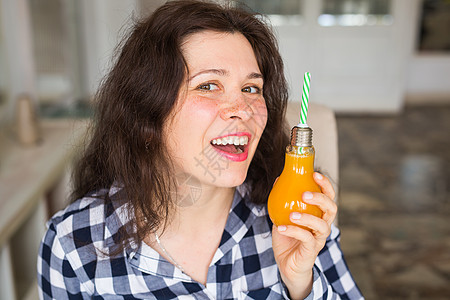 饮食 健康生活方式和戒毒概念     瓶装橙汁的年轻女子看起来像一盏灯橙子房间水果衣服成人液体果汁养分女性玻璃图片