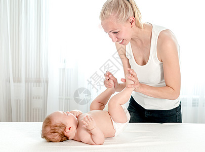 母亲对婴儿进行按摩身体新生女孩医生妈妈疗法治疗父母体操手指图片