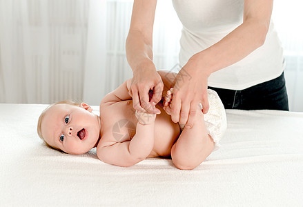 母亲对婴儿进行按摩皮肤治疗女孩身体几个月孩子母性妈妈体操新生图片