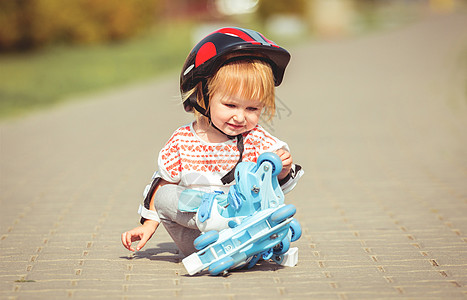穿着溜冰鞋和头盔的2岁女孩游戏童年乐趣森林幸福闲暇安全运动享受公园图片