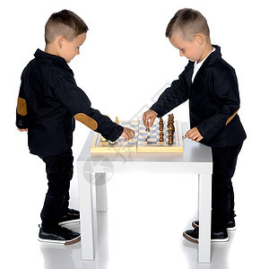两个小男孩下象棋闲暇桌子乐趣棋盘智力活动游戏木板童年兄弟图片