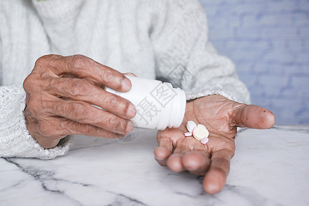 身处异地的年长妇女在服药时图片