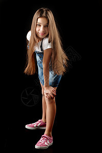 穿戴尼姆服装的小女孩 黑人背景工装裤快乐工作服衣服微笑粉红色头发青春期混血儿女孩图片