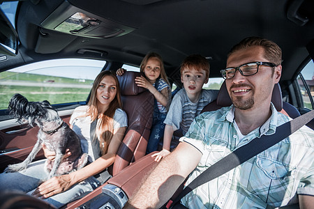 友好家庭乘坐舒适的汽车旅行女士父亲孩子运输司机腰带幸福儿子假期父母图片
