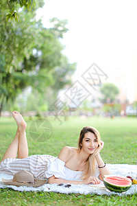 年轻女性阅读书 躺在水果 帽子和草本旁边的格子上 (笑声)图片