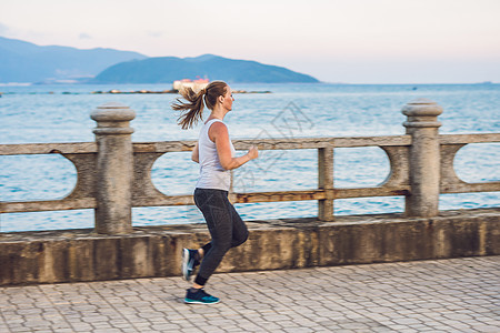 沿海岸区的运动女孩 年轻的女运动员在海边做运动情调海滩衣服空气女性赤脚体操异国运动装杂技图片