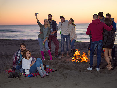 在海滩日落时和朋友共度欢乐的情侣朋友们城市潮人男人派对快乐动作营火沙滩假期图片