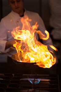 厨师在食物上做烧烤油炸午餐炊具平底锅用餐盘子气体餐厅行动蔬菜图片
