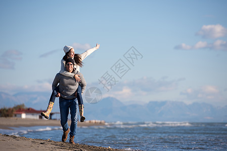 秋天在海滩玩情的情侣夫妻背光潮人女性异性日落女朋友男人海洋快乐背景