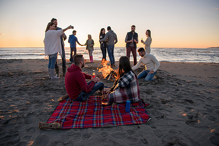 在海滩日落时和朋友共度欢乐的情侣潮人旅行营火乐趣假期场景沙滩夫妻女性活动图片