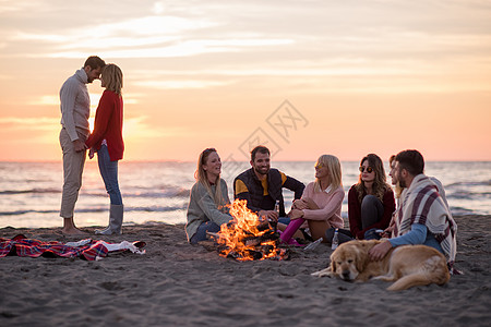 在海滩日落时和朋友共度欢乐的情侣潮人城市乐趣动作旅行篝火假期营火男人友谊图片