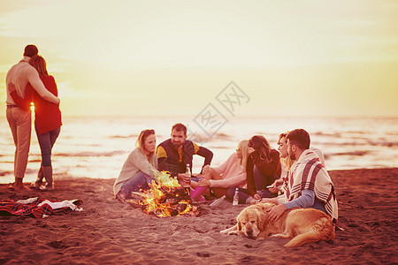 在海滩日落时和朋友共度欢乐的情侣潮人城市派对场景男人衣服夫妻女性享受营火图片