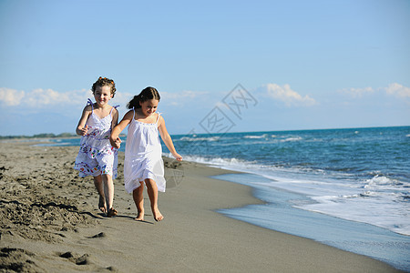 可爱的小女孩在沙滩上奔跑女性季节衣服家庭跑步海滩海洋海岸孩子朋友们图片