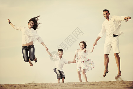 快乐的年轻家庭在海滩上玩得开心喜悦母亲闲暇海洋成人后代旅行支撑游客乐趣图片