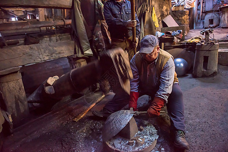 在车间使用机械锤子的铁匠工人燃烧铁匠铺工艺男人辉光火花罢工火焰韧性工匠图片
