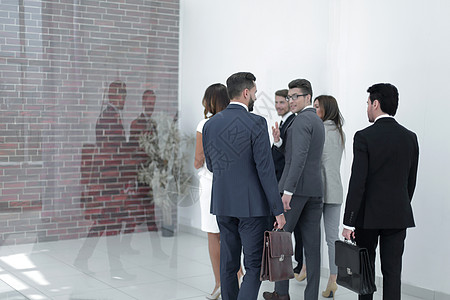 公司雇员在办公大厅内进行工作职业男性团队员工人士利润反射走廊商业团体图片